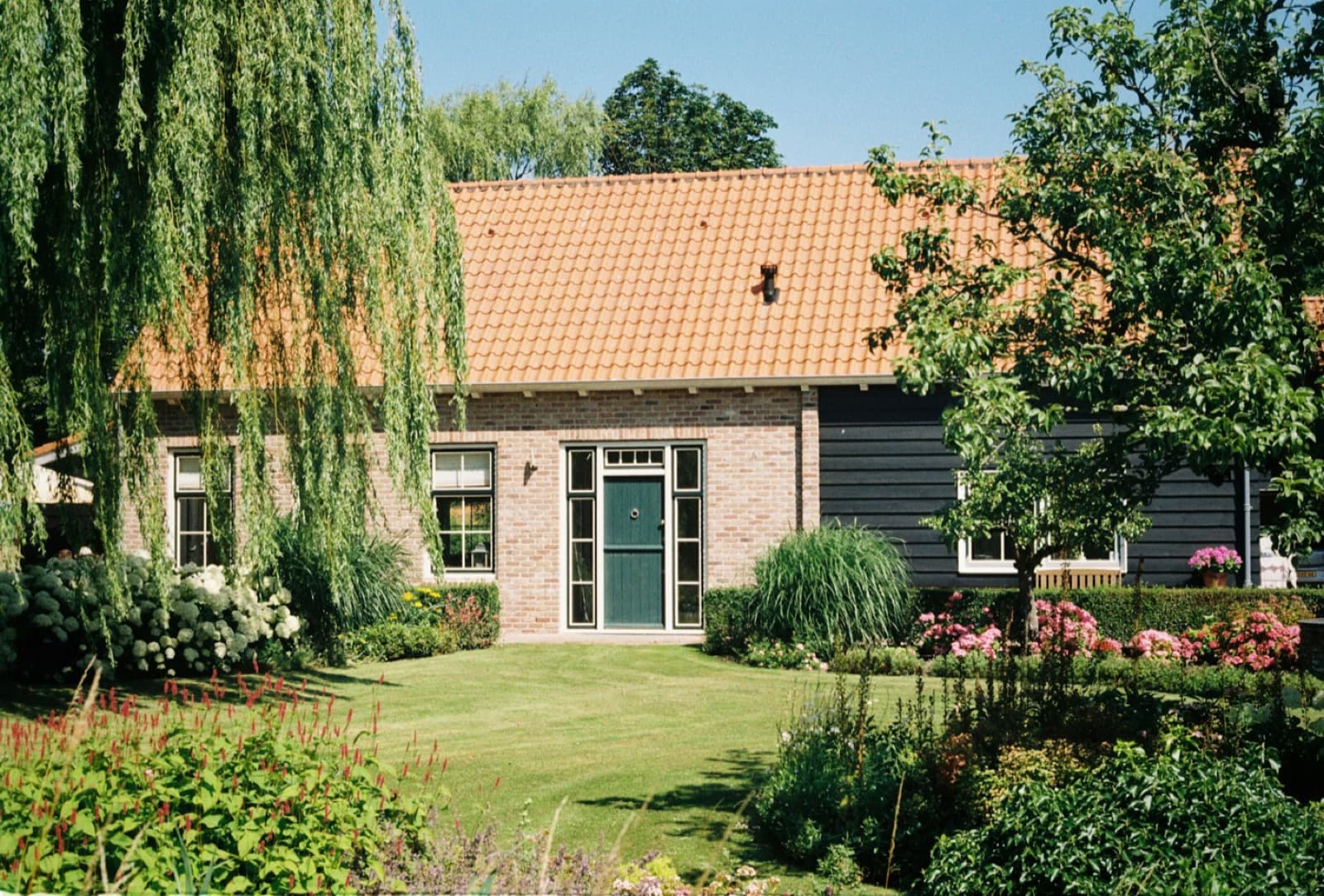 Karakteristieke kluswoning met een tuin vol planten en bloemen